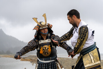 Obraz premium Samurai Warriors in Traditional Armor Fighting on Shore at Stave Lake, Mission, British Columbia, Canada