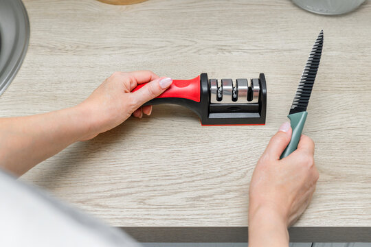 Sharpening a kitchen knife in the home kitchen. knife sharpening process. sharpening a kitchen knife in the home kitchen. manual sharpener for a kitchen knife