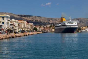Fototapeta premium Ferry boat approaching the vibrant port and promenade of Chios town in Greece