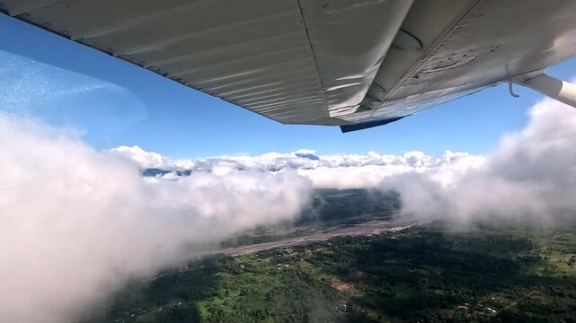 Small Airplane Wing Flying Over Clouds and Forested Mountains, Aerial View of Tropical Ecuador, Remote Aviation Travel, Adventure Transport and Scenic Landscape