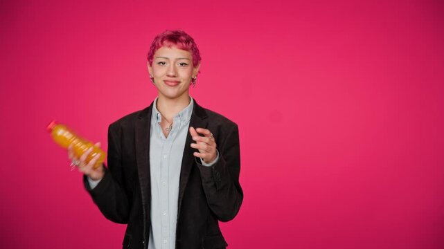 Young person with pink hair drinking orange juice