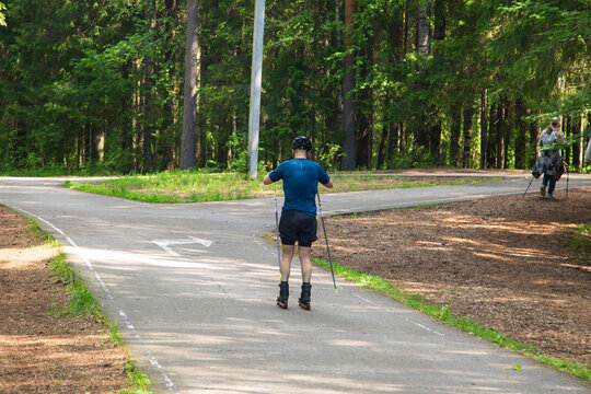 Cross Country Skiling. A man in the park runs on ski rollers.