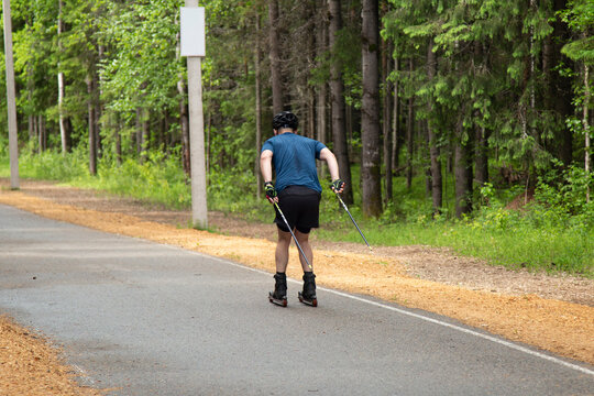 Cross Country Skiling. A man in the park runs on ski rollers.