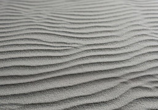 Ultra close-up of fine gray sand raked into gentle, calming waves and subtle ridges, creating a peaceful, soothing background texture, organic, soothing, texture