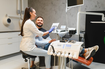 Dentist showing dental x ray to smiling patient
