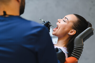 Dentist examining patient's open mouth during checkup