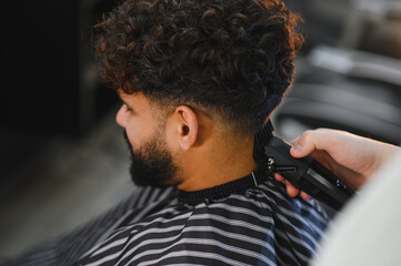 Naklejka premium Stylish man receiving a fresh fade haircut at barbershop