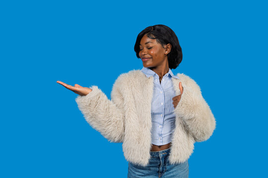 Young black woman presenting product space with thumbs up