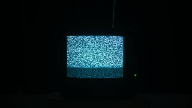 Retro TV, vintage television In a nostalgic setup, a retro TV displays grain on screen, scary halloween night device good for chroma key and green screen