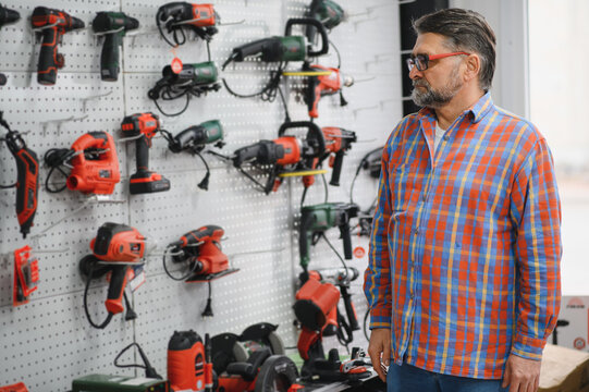 Salesman choosing power tools in hardware store