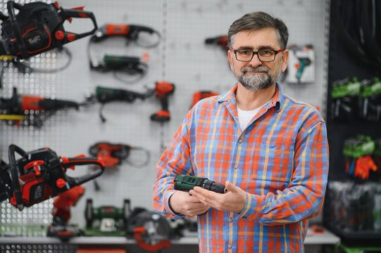 Salesman showing drill in hardware store with power tools
