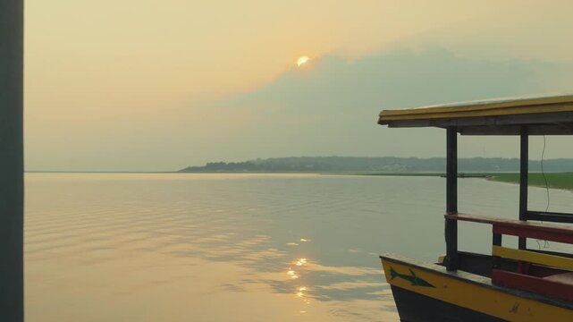Peaceful sunrise over Amazon river with traditional wooden boat in Brazil