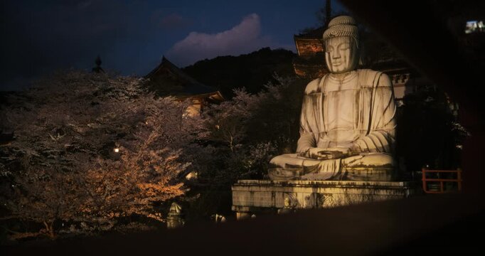 Handheld shot of glowing, ancient Buddha statue at temple