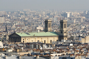 Obraz premium Paris cityscape, with Saint-Vincent-de-Paul church and dense rooftops