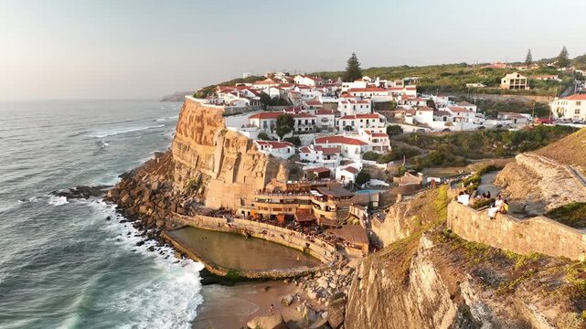 Aerial view of Azenhas do Mar village with white houses perched on a cliff overlooking the Atlantic Ocean and a natural pool in Colares, Lisbon, Portugal.