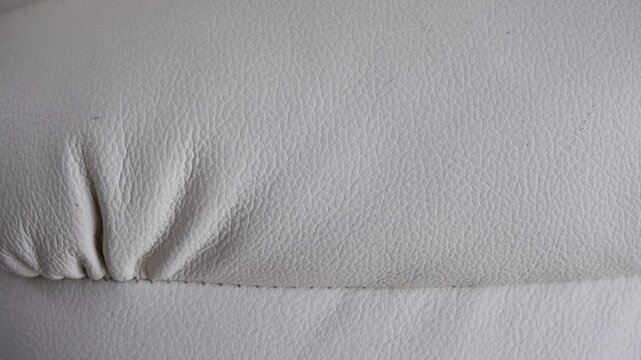 White leather upholstery texture with stitching and subtle wrinkles.