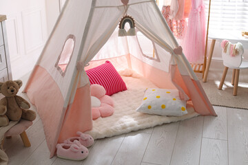 Cute wigwam, clothes, cushions and toy in stylish child's room © New Africa