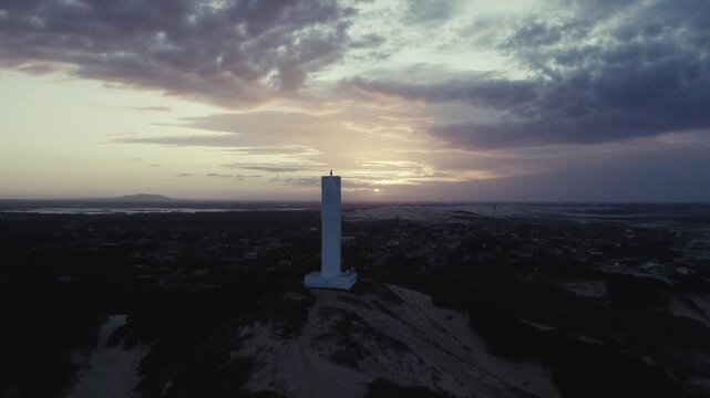 Aerial orbit around Morro Branco lighthouse at sunset in Cear&aacute; Brazil