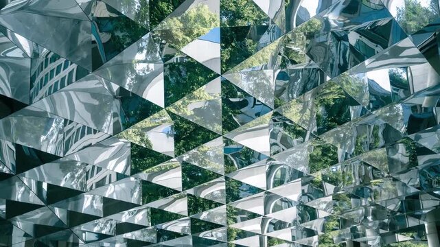Medium shot capturing reflective mirrored metal ceiling panels arranged in a geometric grid enhancing ambient light and adding visual depth