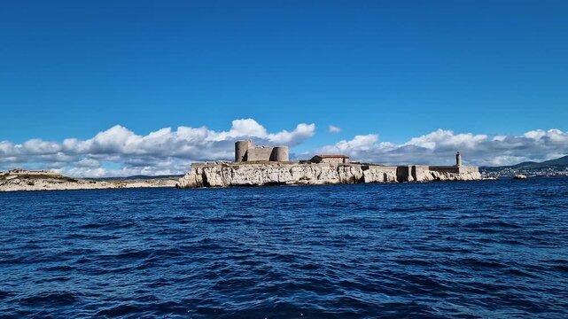 Scenic boat ride view of Chateau d'If castle under a bright blue sky, Mediterranean Sea