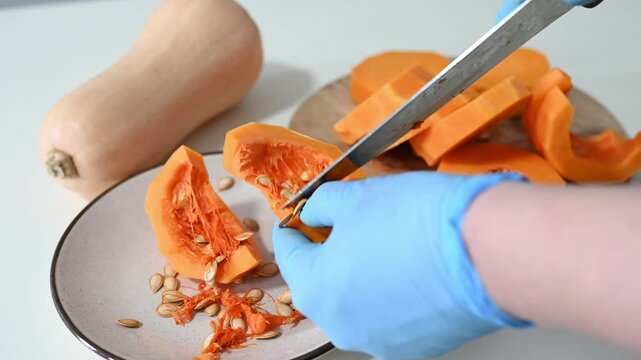 Cutting and preparing butternut squash for cooking at home in a kitchen setting