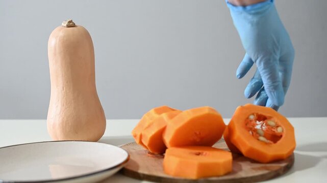 Cutting squash into pieces in a kitchen setting with simple tools and a clear countertop