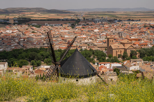 Windmill overlooking the historic town of Consuegra in Castilla-La Mancha, Spain. Scenic view of traditional architecture, countryside, and the famous Don Quixote landscape.