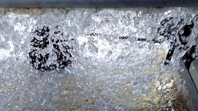 Close Up of Water Splashing and Spraying Inside Industrial Cooling Tower