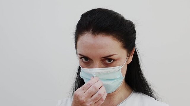 A female doctor puts a mask on her face