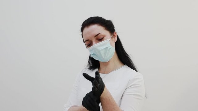 A female doctor puts on rubber gloves