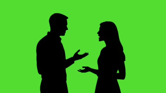  silhouette of a man and a woman talking standing in front of a green screen background