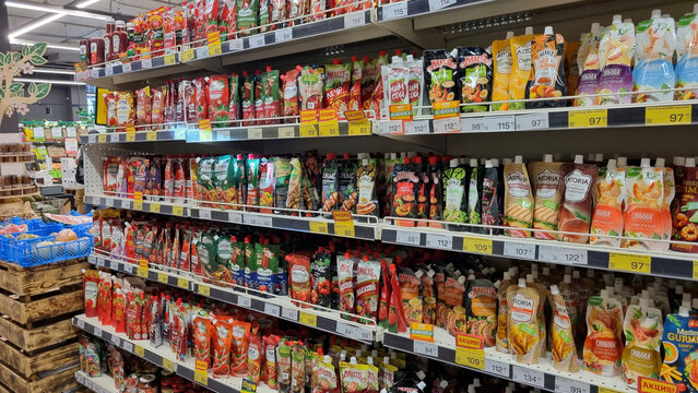 Condiment and Sauce Aisle in Grocery Store, Wide Supermarket Shelf with Promotional Offers, Editorial
