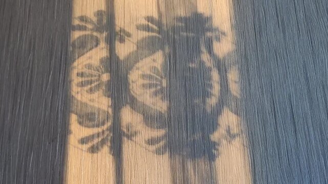 Sunlight casting delicate shadows through a lacy vintage-style curtain, creating elegant patterns on the interior surface.