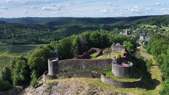 Vue a&eacute;rienne panoramique des ruines m&eacute;di&eacute;vales du ch&acirc;teau de Herbeumont en Belgique, dans la province du Luxembourg en Wallonie. Au fond le village les champs et les for&ecirc;ts au mois de juin 2026