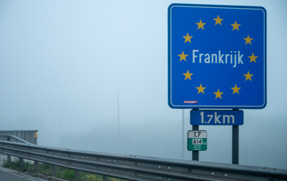View of a French border sign on  autoroute with overhead directional signs pointing to major cities like Paris, Bordeaux, Lille, Calais, showing lanes, traffic and motorway infrastructure, road signes