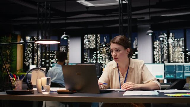 Anxious businesswoman tearing sheet of paper after writing incorrect data during late night work session. Worried manager struggles with stress, burnout and poor results, trying to find solution.