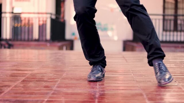 Legs of an adult man in formal attire dancing and stomping. Cueca brava, a typical Chilean dance, representing Chilean identity. National holidays.