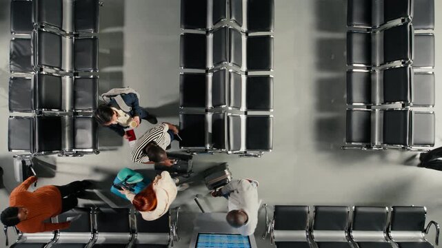 Navigating airport, congested terminal hallway and top down view of travelers. Moving through air transportation hub, busy passenger flow concept and High angle shot of tourists with luggage