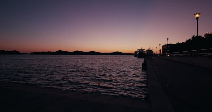 Twilight view of the waterfront promenade and Adriatic Sea after sunset in Sibenik, Croatia.