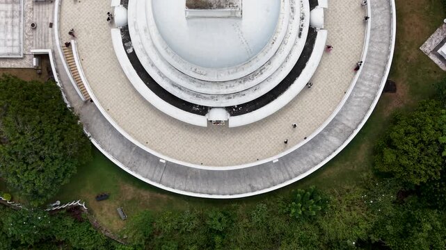 Aerial view of Japanese Peace Pagoda - Rumassala with people walking on circular walkways surrounded by lush greenery in Unawatuna, Southern Province, Sri Lanka.