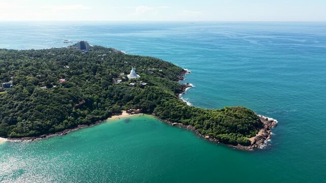 Aerial view of the Japanese Peace Pagoda - Rumassala surrounded by lush jungle and turquoise ocean waters in Unawatuna, Southern Province, Sri Lanka.