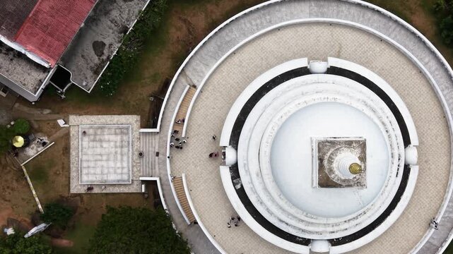 Aerial view of Japanese Peace Pagoda - Rumassala showing the white circular stupa and people walking on the walkway Unawatuna, Southern Province, Sri Lanka.