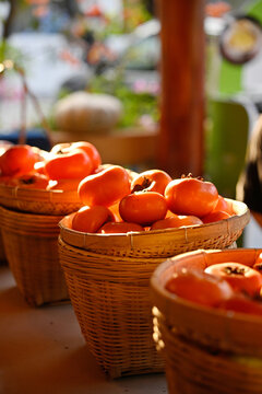 Closeup of ripe, picked persimmons in a bamboo basket