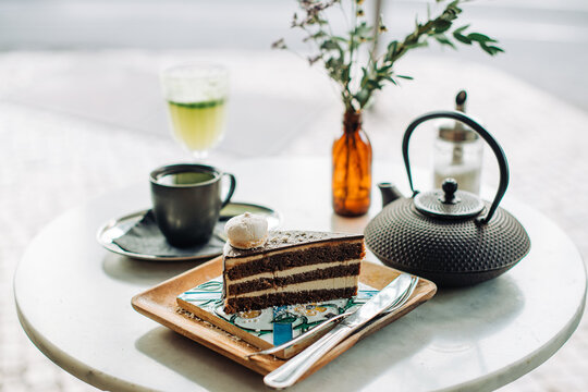 Chocolate Cake Slice with Tea and Coffee on Cafe Table