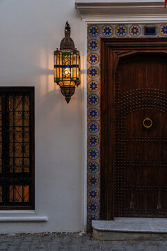 Large bright lighting lantern on wall at decorative door