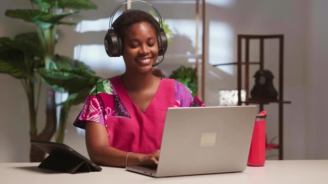 Happy African female student teleconferencing and using a laptop for remote learning