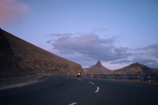 Scenic Motorcycle Ride on Winding Road at Dusk in Mountainous Region