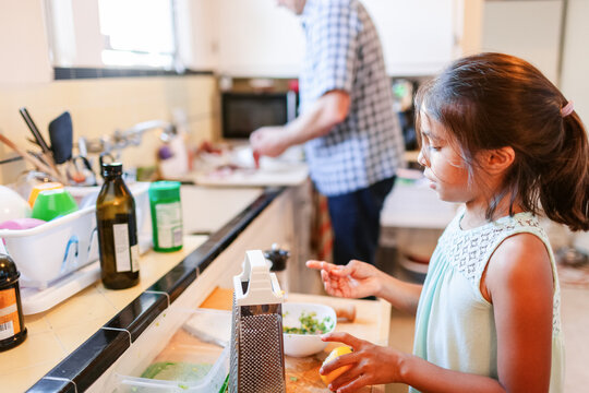Girl preparing lunch with her dad at kitchen