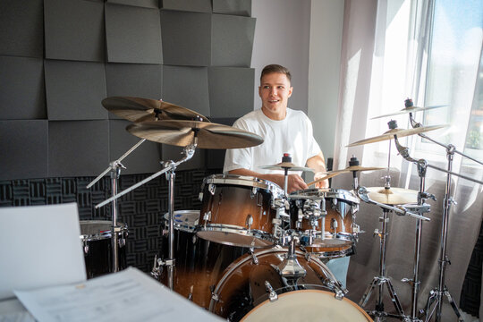 Young Man Plays Drums in a Home Studio During the Day