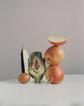 Modern stil life with apples and artichoke on a table